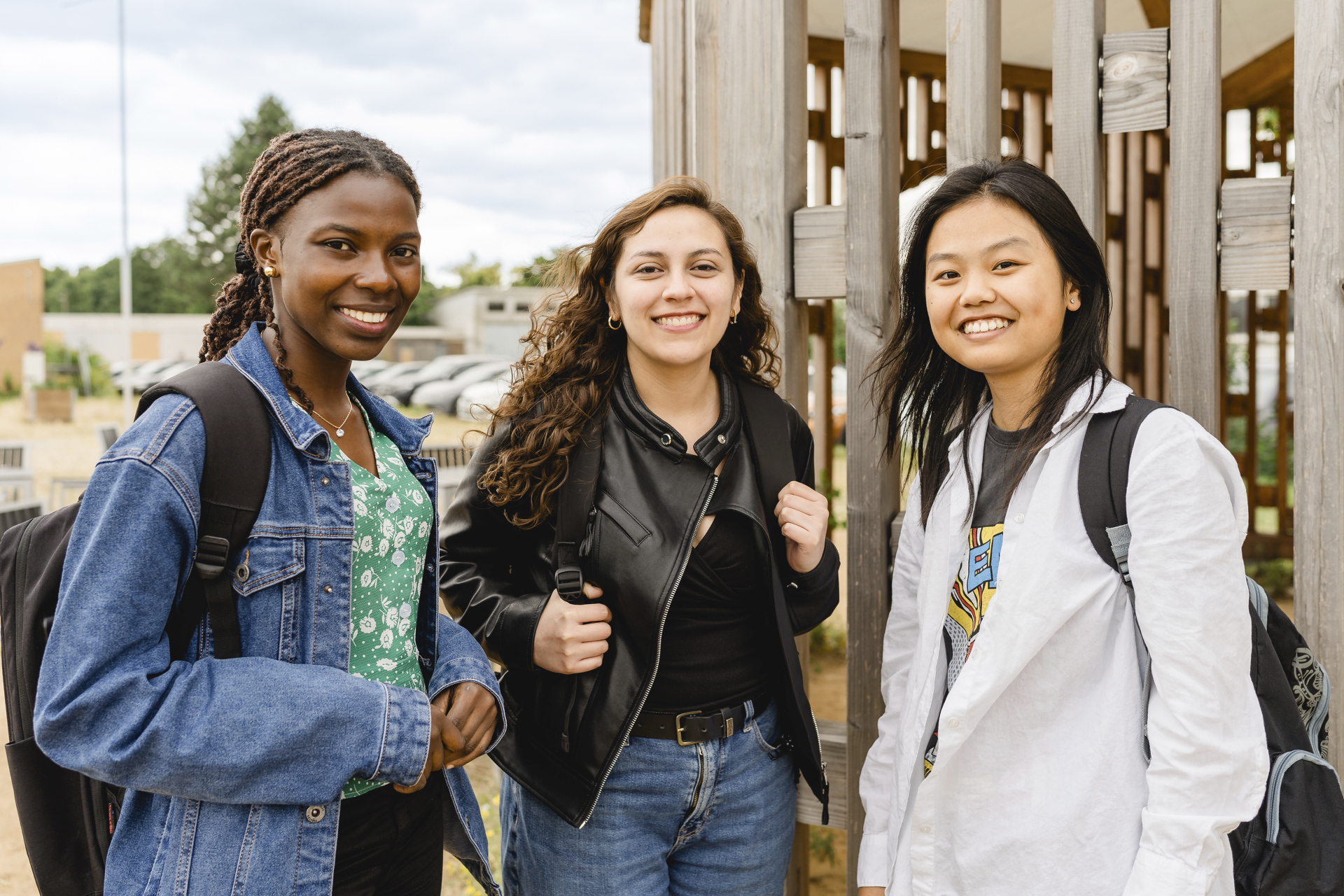 Drei Studentinnen stehen auf dem Nordcampus der TU Braunschweig und lächeln in die Kamera.