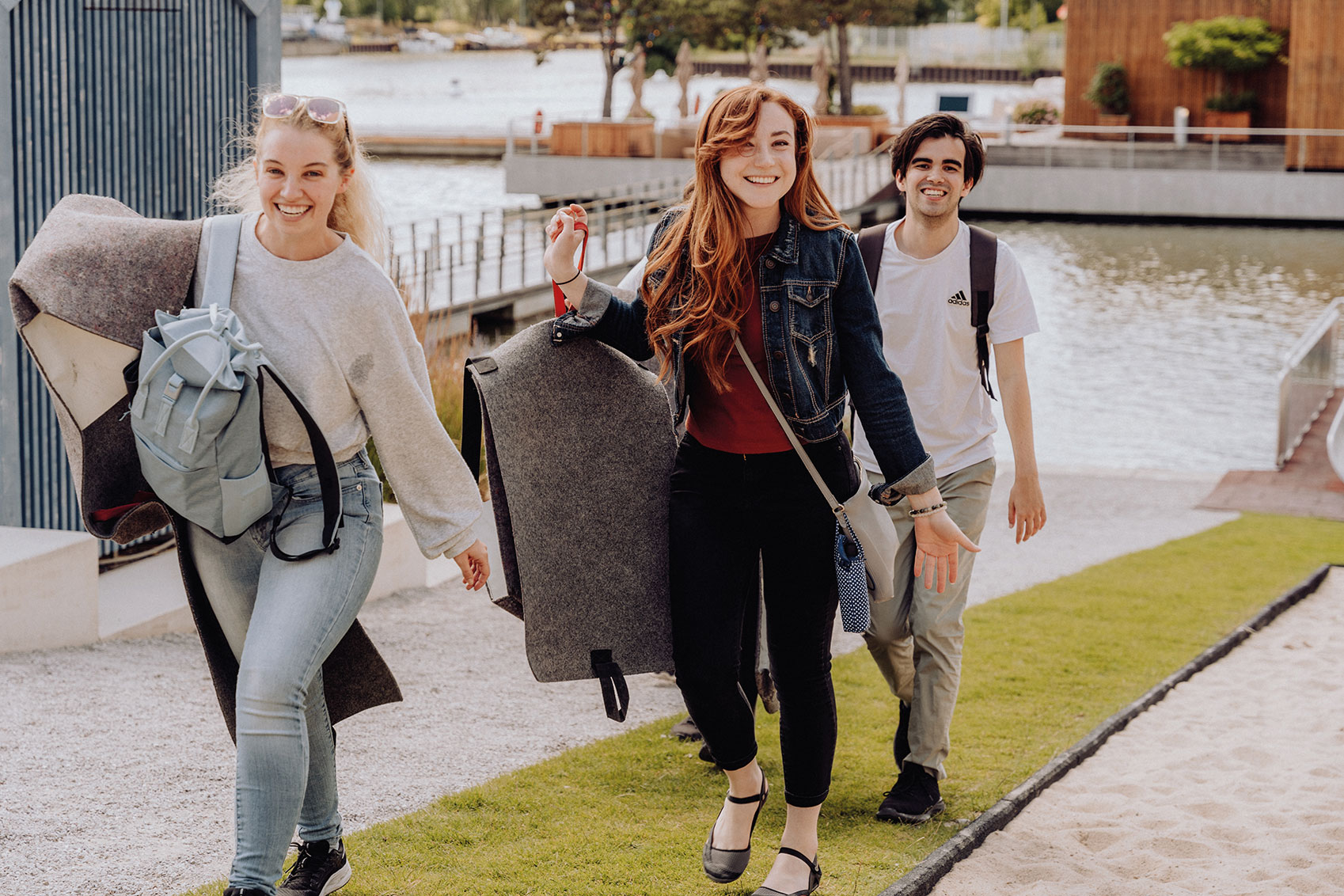 Three Summer School participants laugh as they leave the slides at the Autostadt Wolfsburg.