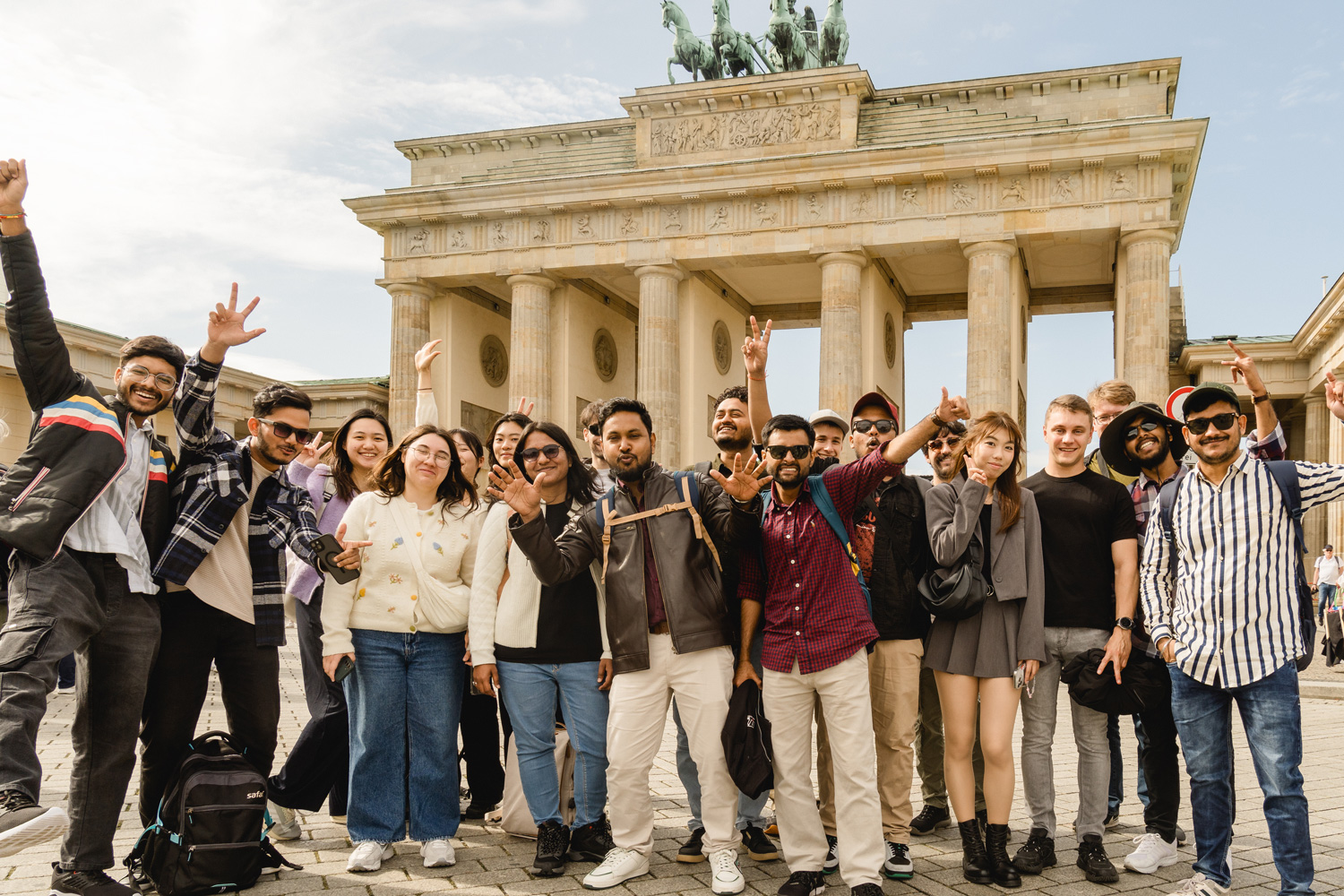 Eine Gruppe von Studierenden steht für ein Gruppenfoto zusammen. Im Hintergrund ist das Brandenbuerger Tor zu erkennen. 