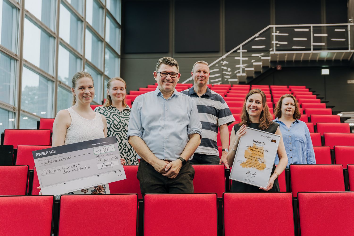 Team Servicestelle Alumni & Career im Audimax mit Urkunde und Preisgeld-Dokument
