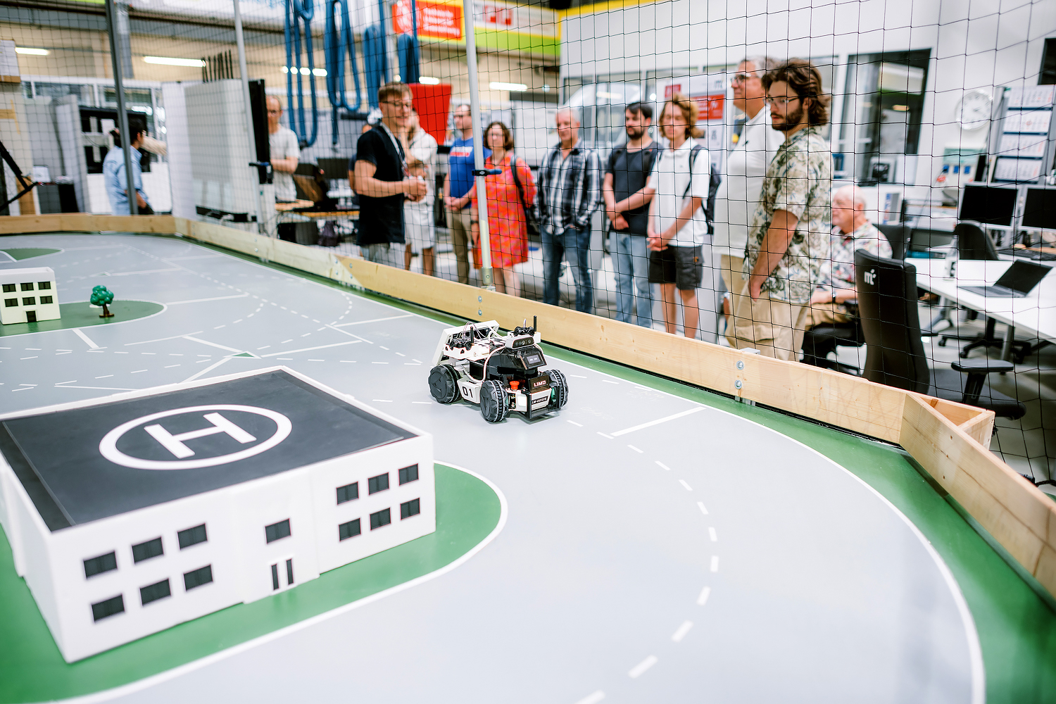 CampusXperience im NFF-Technikum: Wissenschaftlicher Mitarbeiter des ITL erläutert autonome Roboterfahrzeuge einer Besuchergruppe