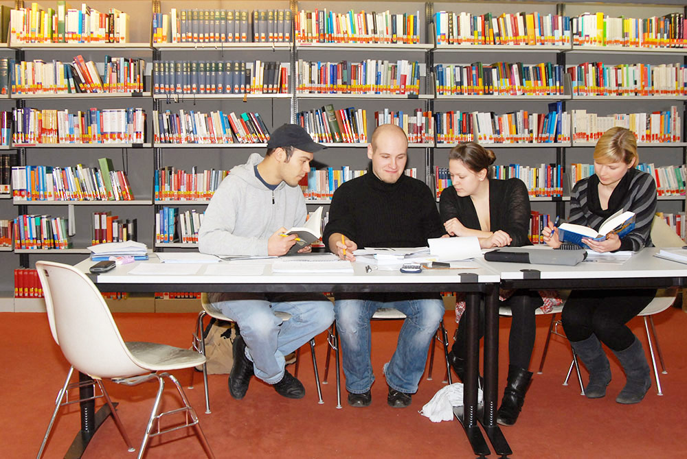 Studierende an einem Tisch in der Bibliothek