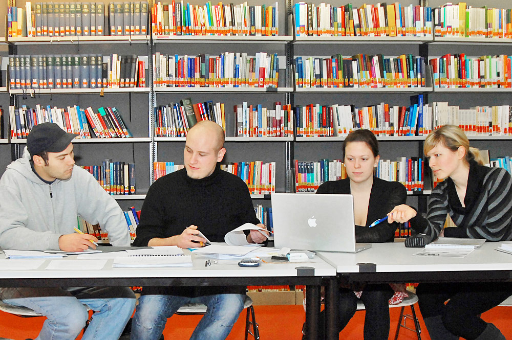 Studierende an einem Tisch in der Bibliothek