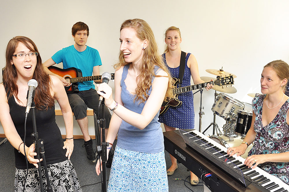 Studierende spielen verschiedene Instrumente und singen