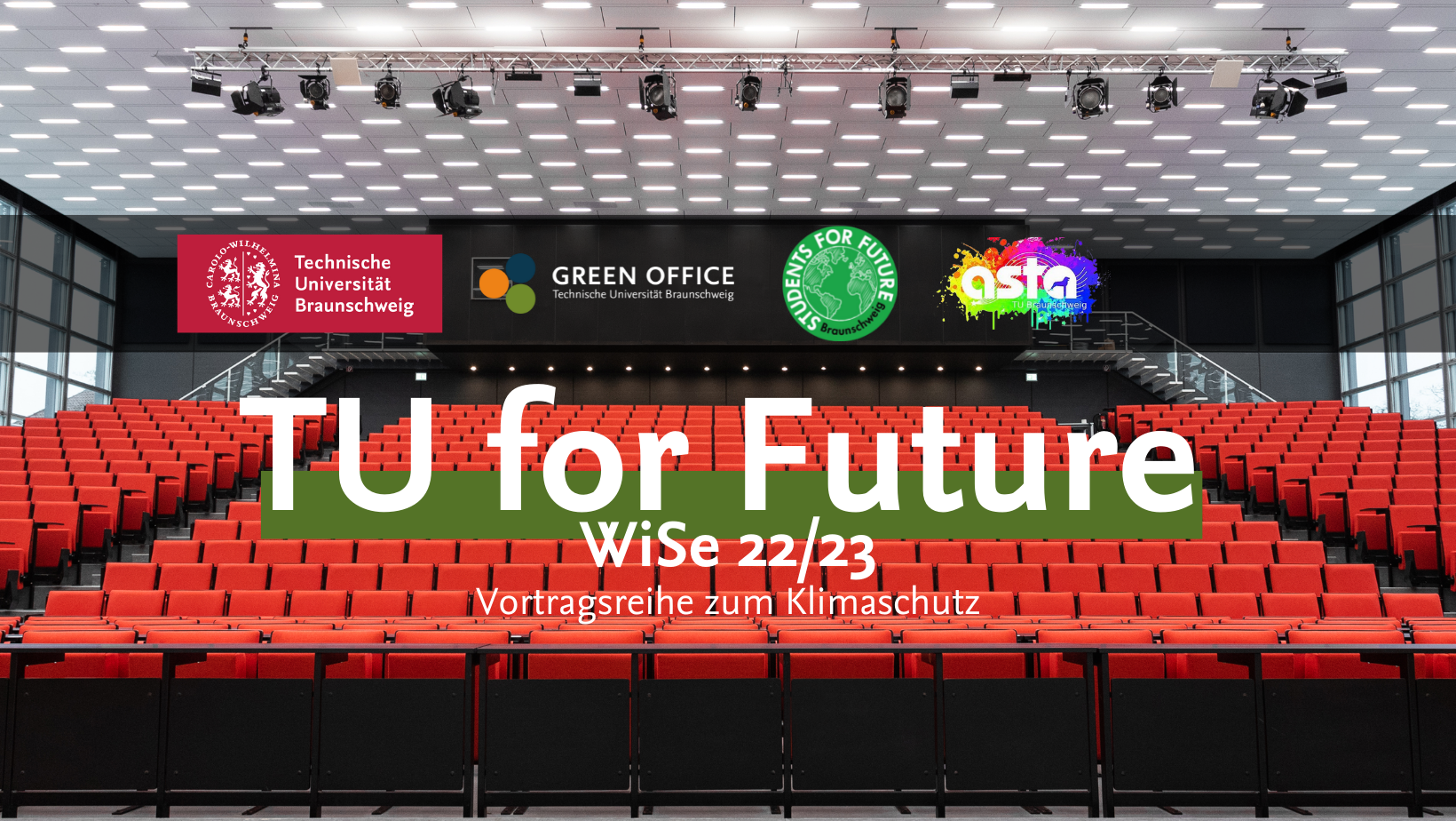 Es handelt sich um ein Werbungs-Banner der TU for Future Vorlesungsreihe. Zu sehen ist dabei das volle Audimax. Davor steht in großer Schrift "TU for Future". Außerdem sind die Logos von der TU Braunschweig, den Students for Future, dem Green Office und dem AStA dort zu sehen.