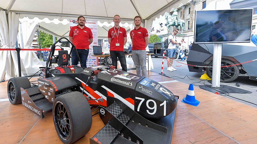 Das LionsRacingTeam vor einem Rennfahrzeug während des "Public Day" am 3. Juni 2023 in Braunschweig.