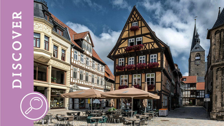 Ein Platz mit Tischen und Stühlen und Fachwerkhäusern in Quedlinburg