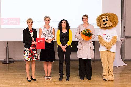 Lehrende mit Präsidentin, Vizepräsidentin und Ministerin auf der Bühne