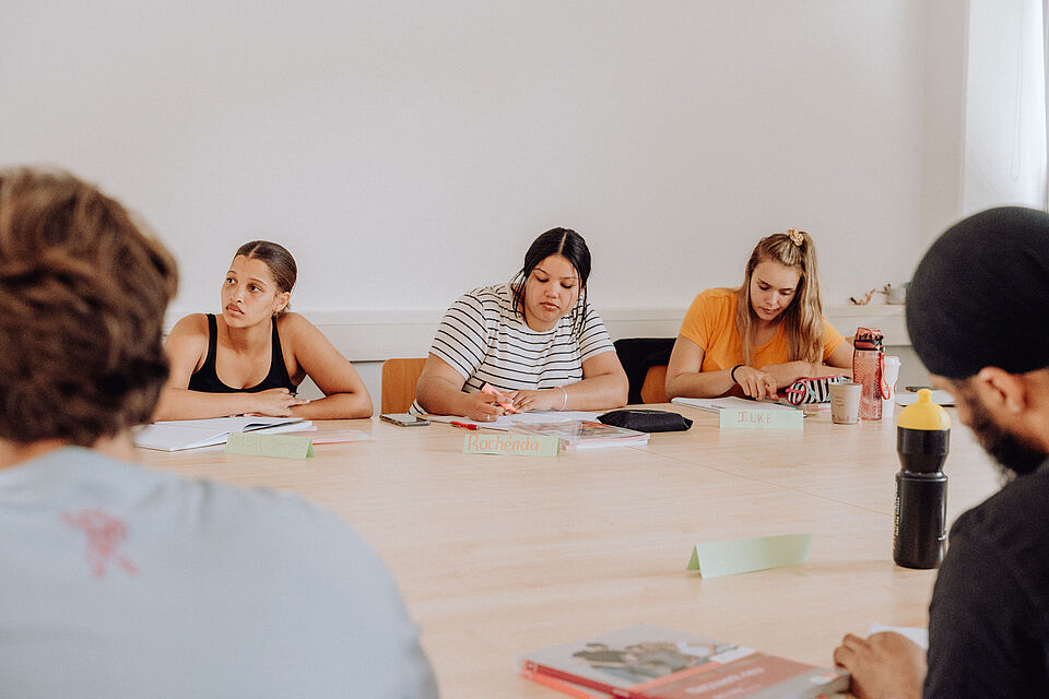 Participants of the Summer School sit in a teaching room and take notes.