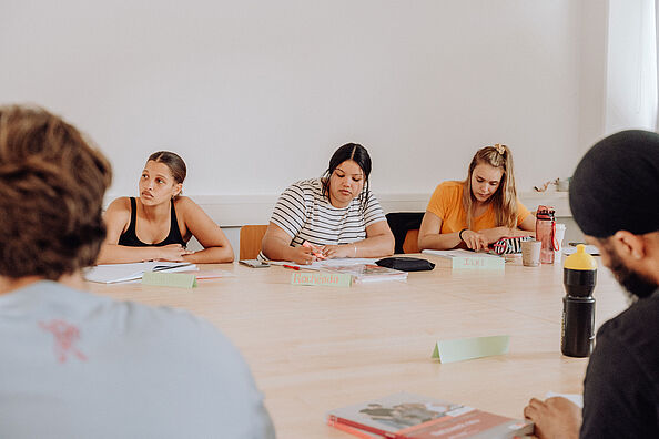 Participants of the Summer School sit in a teaching room and take notes.