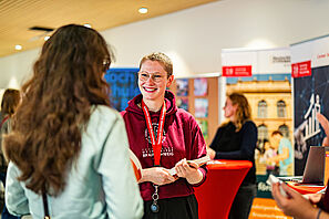 Eine TU Mitarbeiterin unterhält sich mit einer Studieninteressierten auf der Messe
