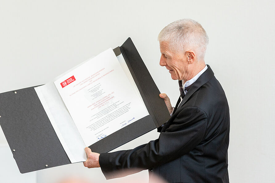 Prof. Rainald Löhner präsentiert die Urkunde