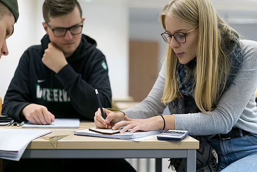 Studierende arbeiten mit einem mechanischen Modell