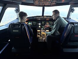 Jonas Füllgraf explainsthe cockpit of the cabin simulator