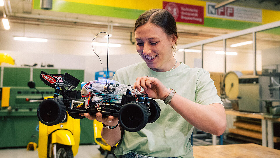 Studierende mit Batterie-betriebenem Fahrzeug.