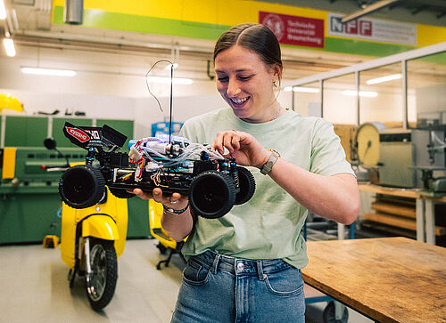 Studierende mit Batterie-betriebenem Fahrzeug.