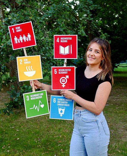 Mia Gutschalk hält die SDgs 1 bis 6 in den Händen. 