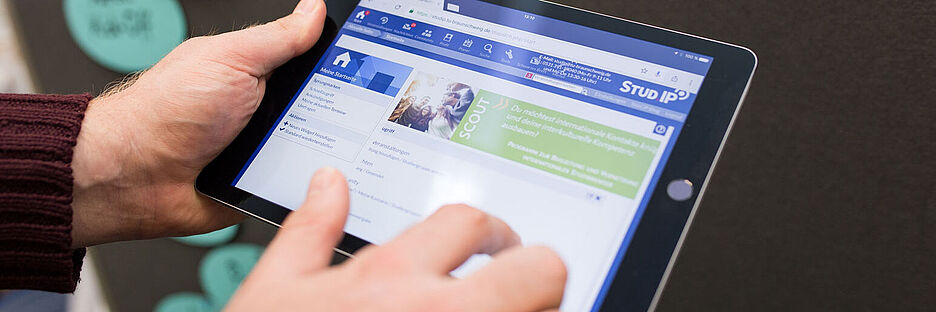 Eine Person hält ein Tablet in der Hand