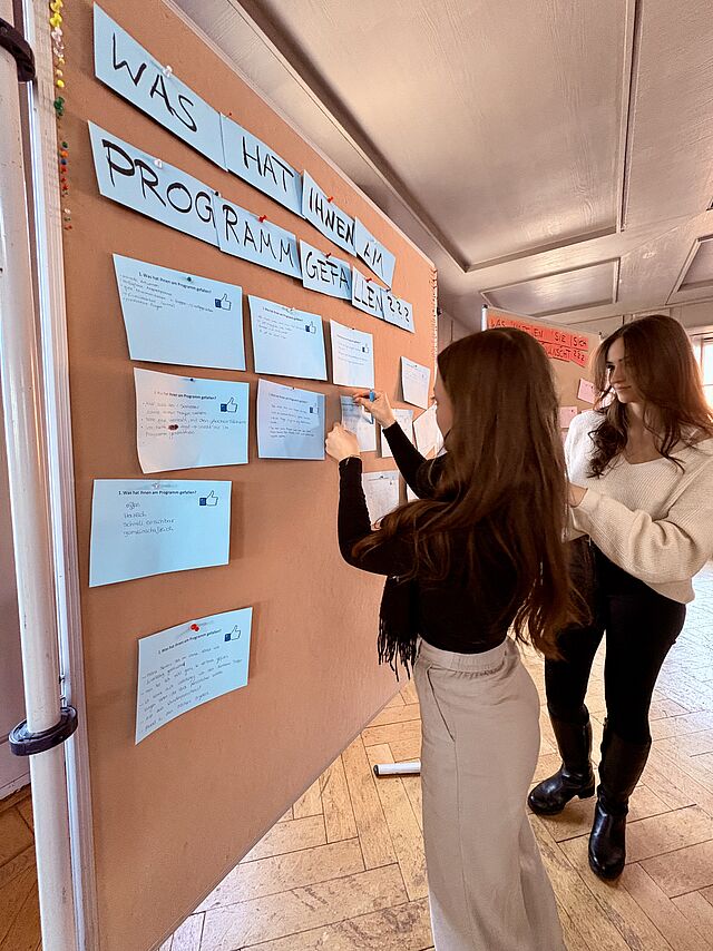 Studierende an Pinnwand