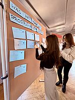 Studierende an Pinnwand