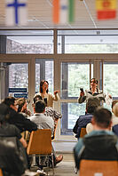 Studierende und die Organisatorinnen des Sprachcafés spielen ein Sprachenquiz.