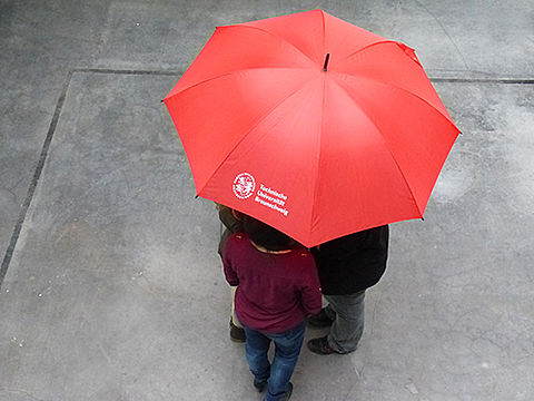 Roter Regenschirm mit Logo der TU Braunschweig