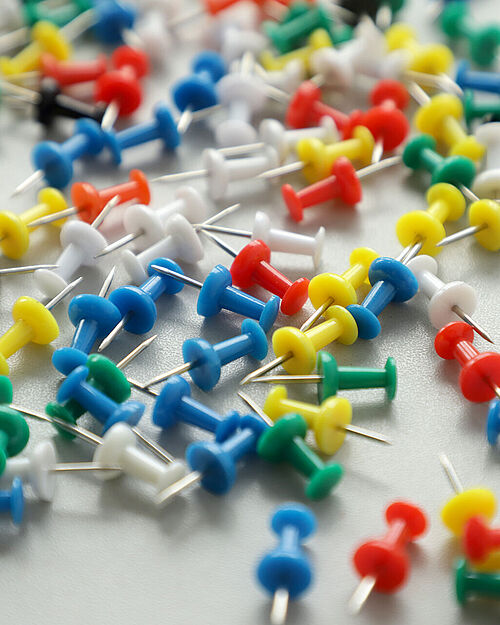 [Translate to English:] Pins auf einem Tisch