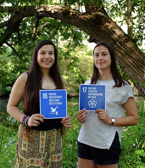Mitglieder der Fairtrade University Inititative halten die SDGs 16 und 17 in den Händen. 