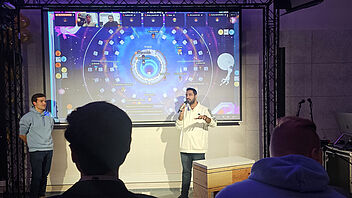 Zuschauer beobachten zwei Studenten, die eine Präsentation halten