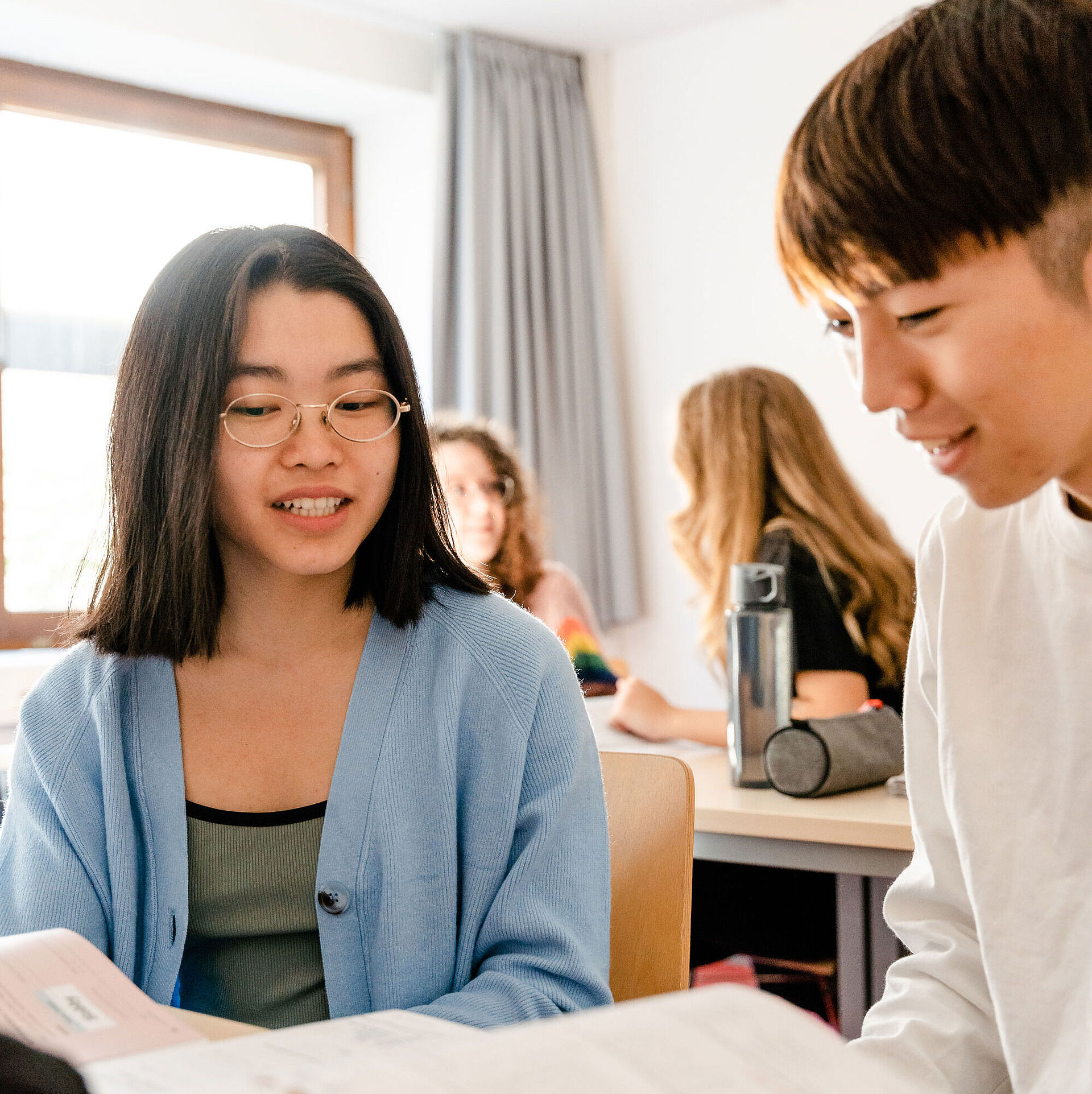 Two students exchange ideas in class.