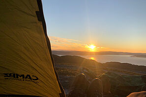 Blick aus einem Zelt über eine norwegische Berg- und Seenlandschaft.