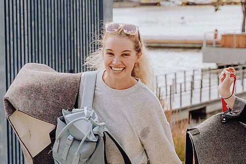 Three Summer School participants laugh as they leave the slides at the Autostadt Wolfsburg.