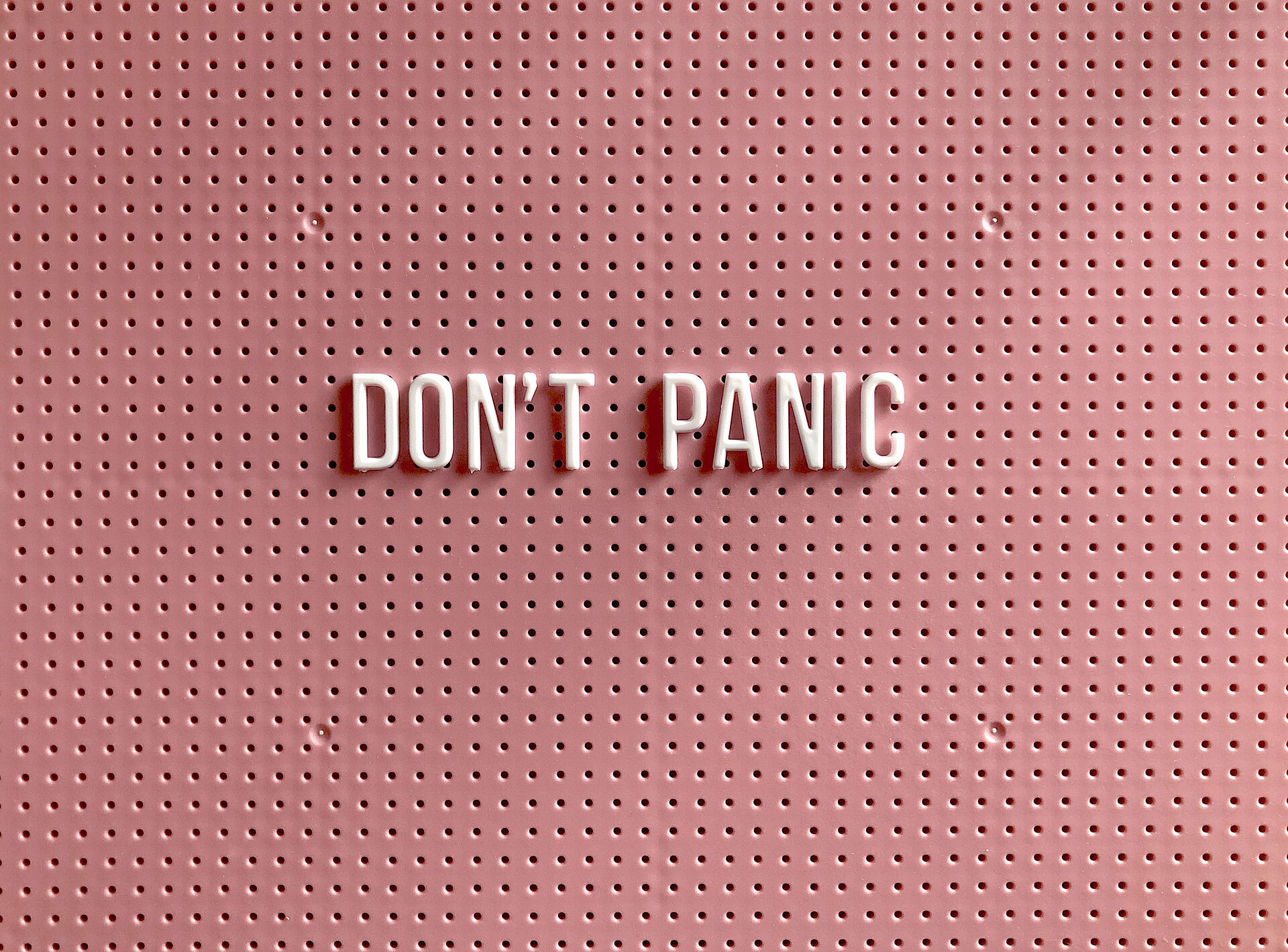 Schriftzug "Don't Panic" auf rosa Hintergrund
