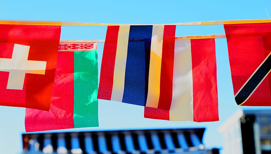 The flags of various countries hang from two horizontally stretched strings