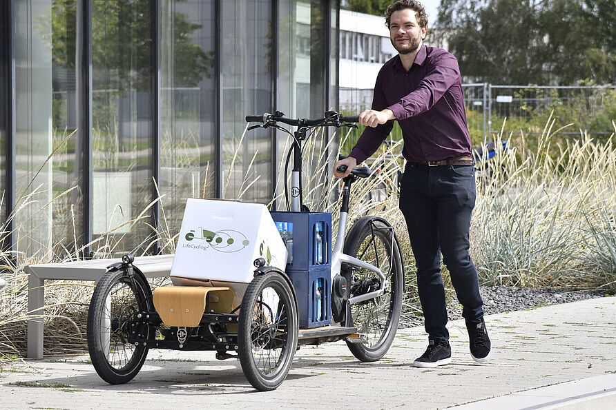 Junger Mann schieb ein Lastenfahrrad vor dem NFF-Gebäude