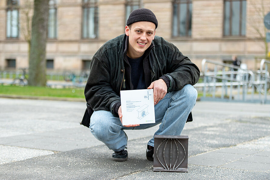 Linus Schmitz mit dem Förderpreis des Deutschen Stahlbaues und einem der fünf Demonstratoren.