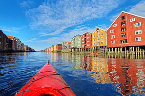 Blick vom Kanu aus auf die bunten Häuser in der norwegischen Stadt Trondheim.