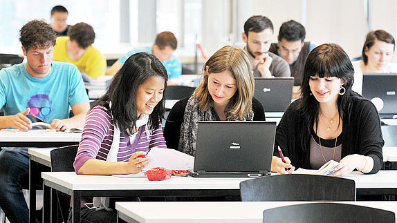 Studierende arbeiten an Laptops