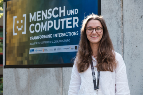 Miriam Garaal neben dem Plakat der Konferenz