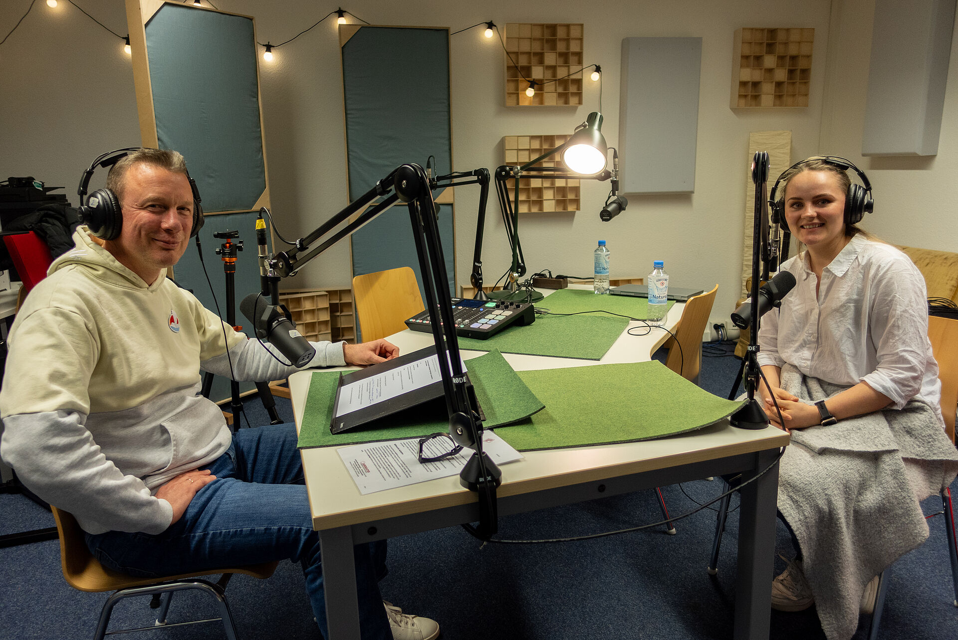 Zu sehen sind Knud Ahlborn und Pia Krone in einer Podcast-Aufnahme-Situation.