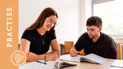 Zwei Studierende schauen auf Bücher