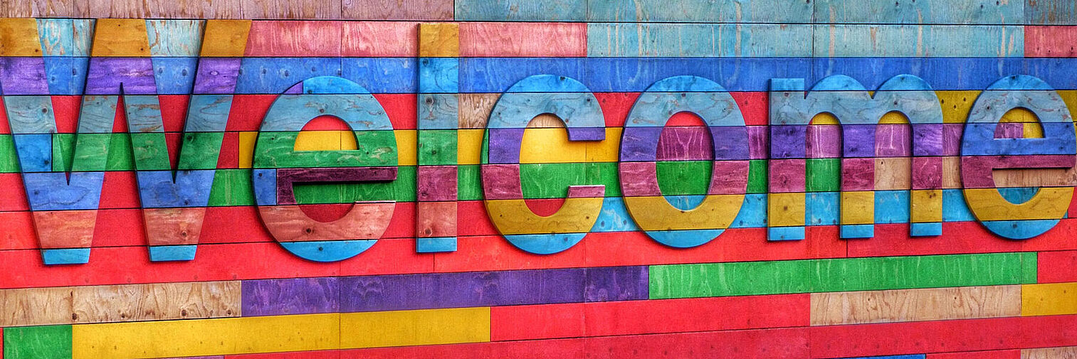 Bunte Wand mit Schriftzug "Welcome" 