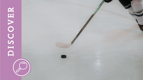 Ein Eishockeyspieler spielt einen Puck vor sich her