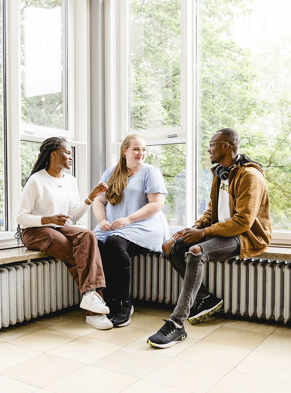  Three students are sitting in the Old Building of TU Braunschweig and talking to each other.
