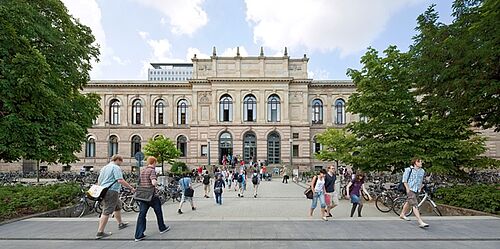 Menschen auf dem Campus vor dem Altgebäude der TU Braunschweig