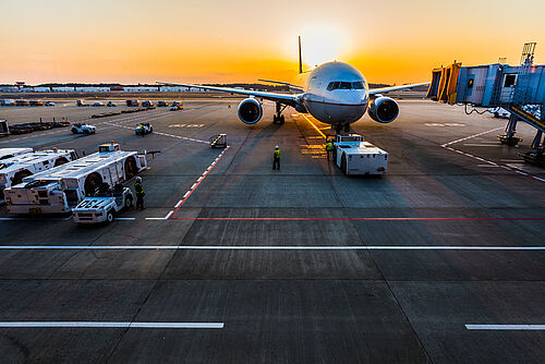 An airplane at the airport in the sunset.