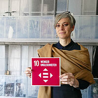 Prof. Dr. Tatjana Schneider hält die Karte zum SDG 10. 