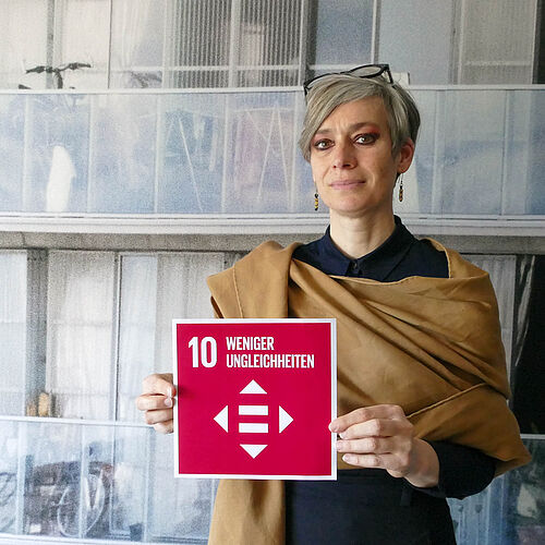 Prof. Dr. Tatjana Schneider hält die Karte zum SDG 10. 