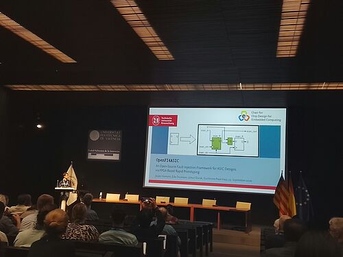 Jasper Homann präsentiert OpenFI4ASIC vor dem Publikum der SafeComp 2026 in Valencia.