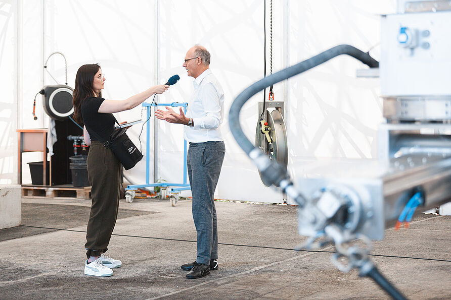Prof. Kloft wird mit Mikrofon interviewt